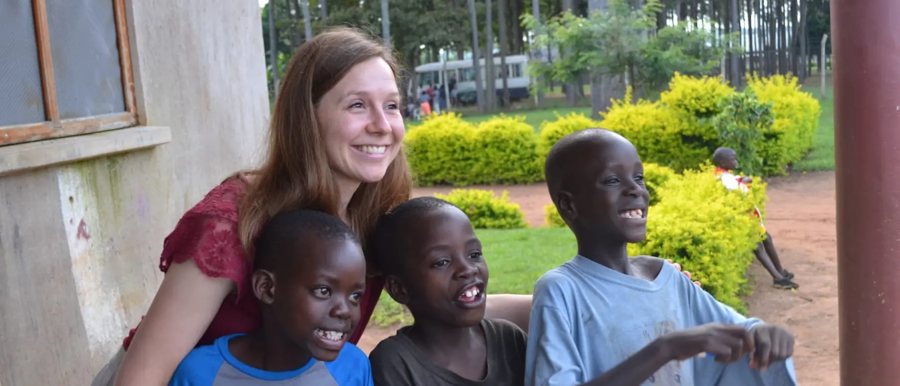 Henkel employee Monika Böhnke is posing for a photo with three boys from Sonrise Ministries.