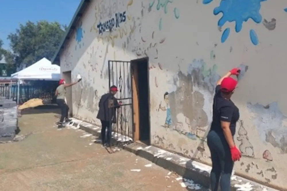 Henkel volunteers painting the wall of one of the classroom buildings.
