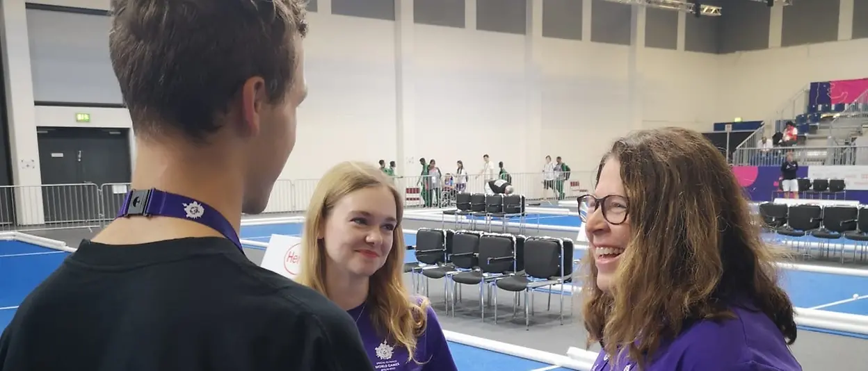 Melissa and Anna talk to one of the boccia referres to align tasks before the upcoming matches.