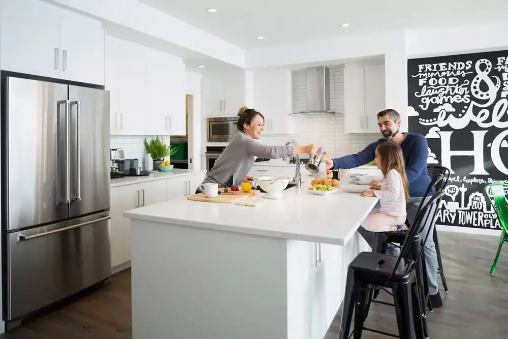 Man, woman and kid eating in a kitchen