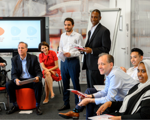 O echipă diversă Henkel stă împreună la un atelier și se uită la vorbitor
