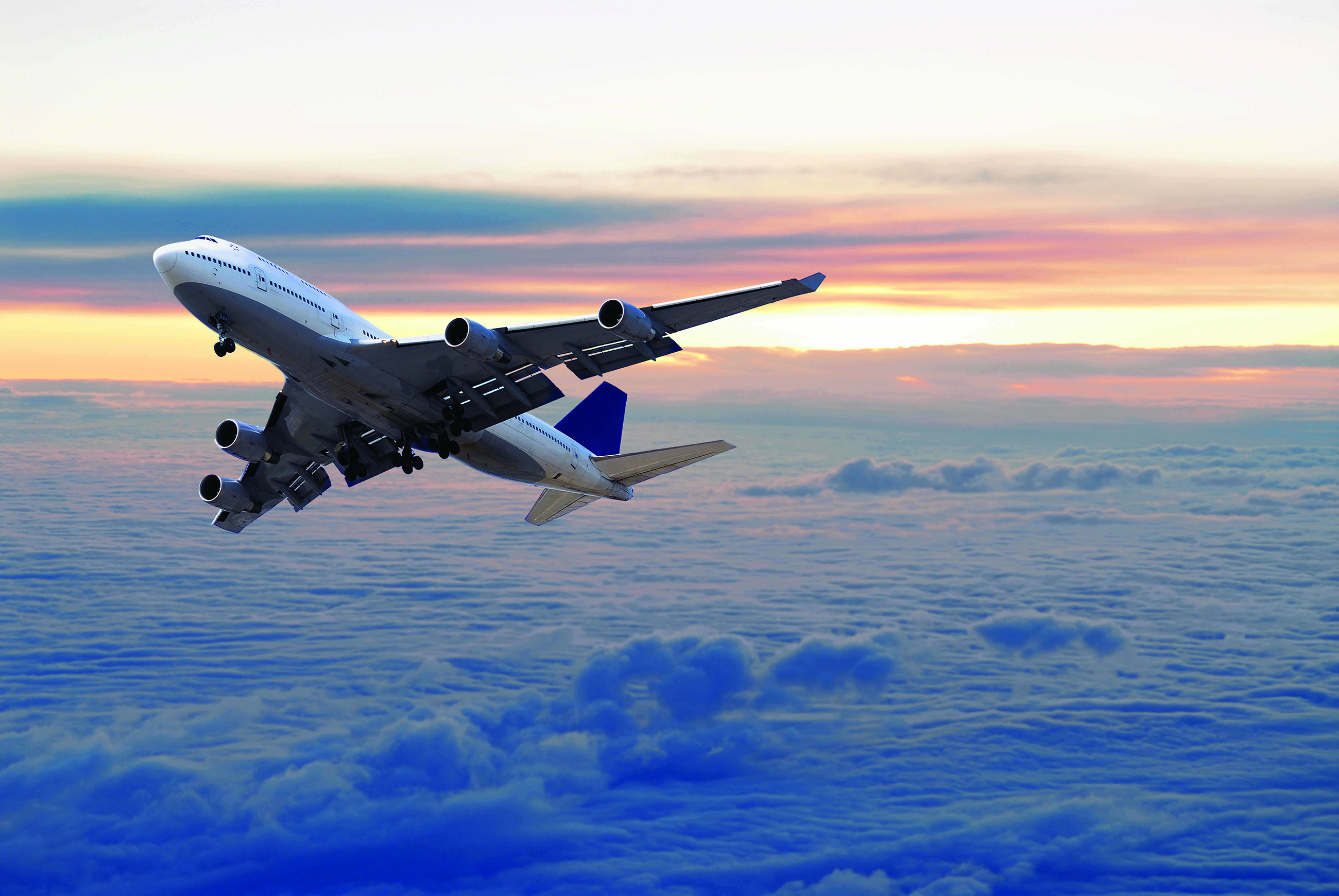 airplane in flight above a cloud blanket