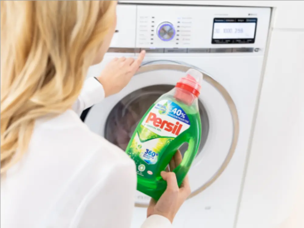 A woman holding the product Persil in her hands.