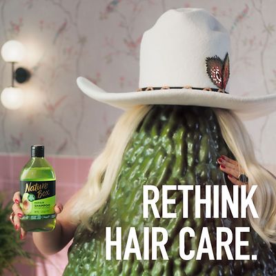 A Nature Box shampoo advertisement with the cowboy hat wearing blonde avocado