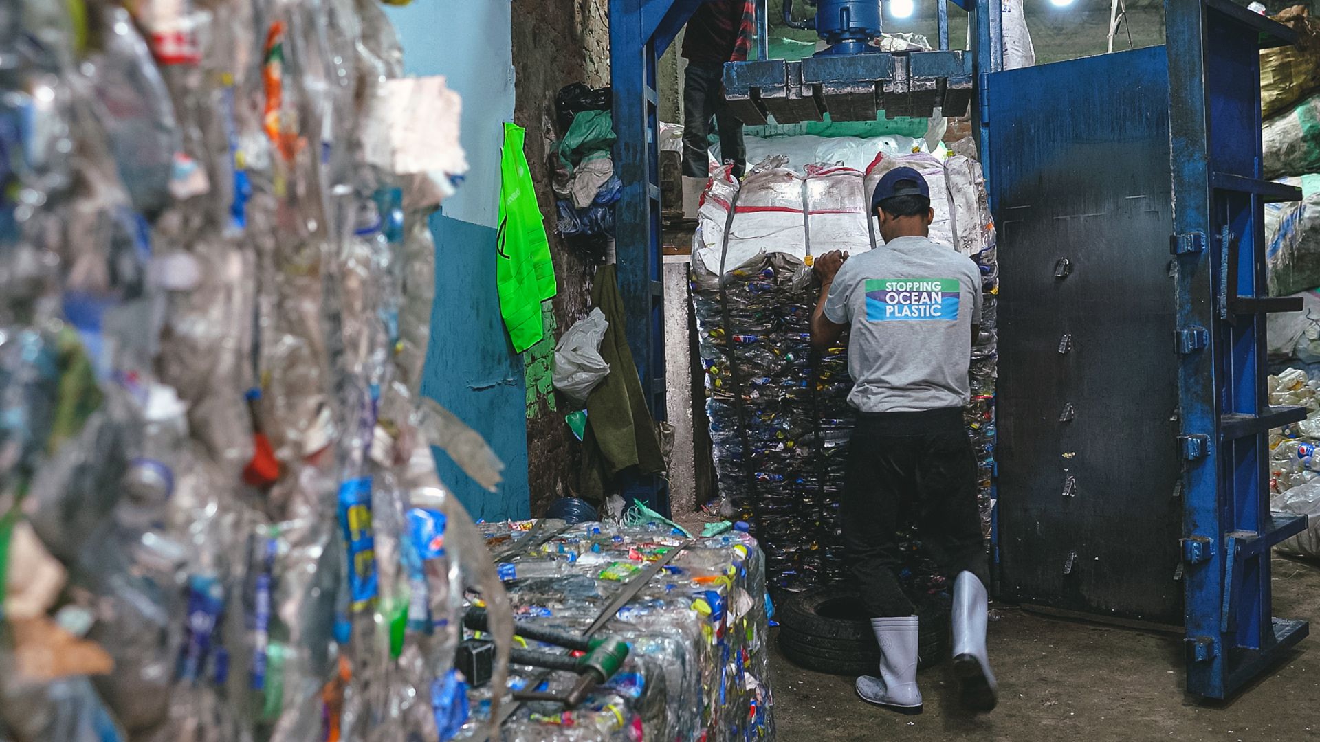 A Plastic Bank employee pulls a block of compressed plastic waste from the facility. 