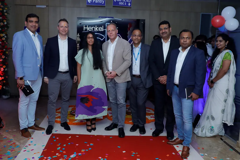 Nilesh Mhatre, Frank Tenbrock, Roshni Nadar Malhotra, Michael Nilles, Ashish Gupta, Sunil Kumar, Mithun Kumar (from left) standing in a half circle in the Global Technology Center. 