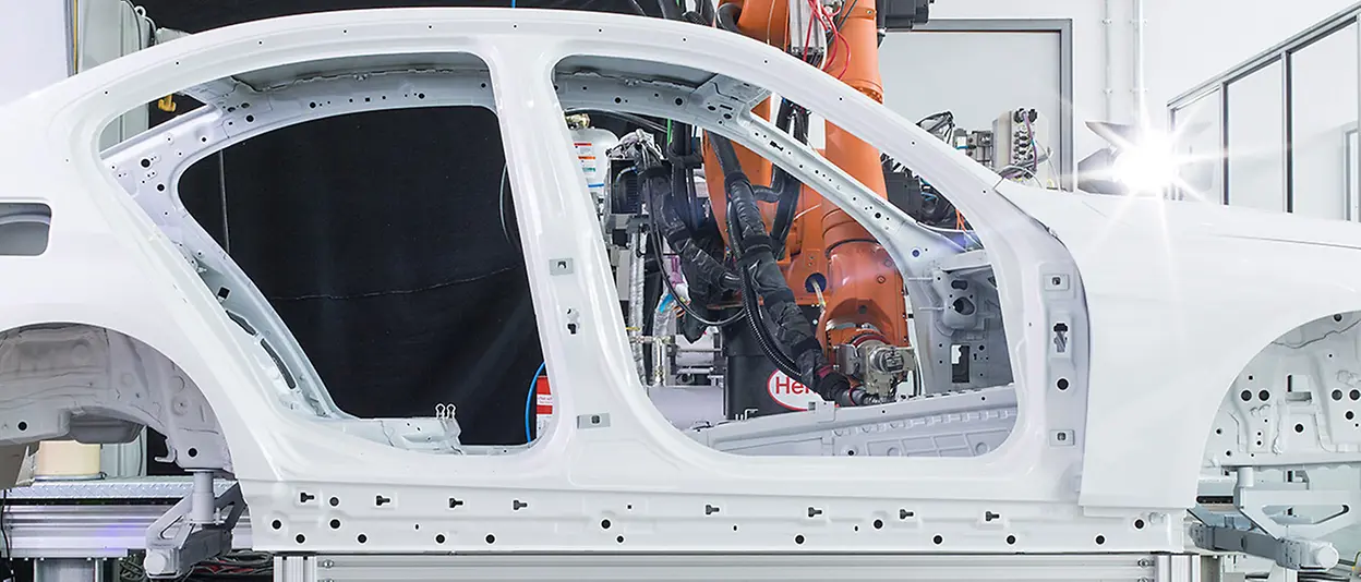 A robot applying adhesive to a car body