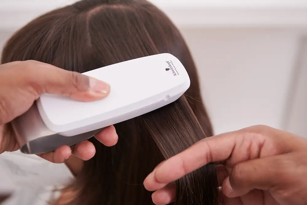 The SalonLab Smart Analyzer is used on a brunette client.