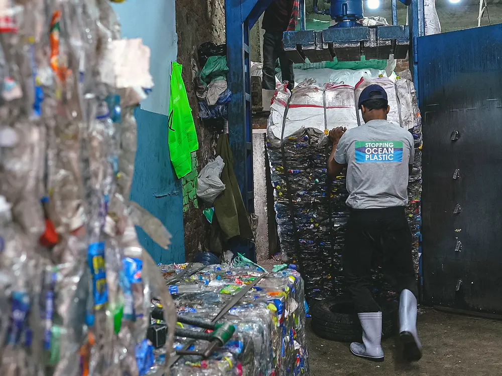 Worker carrying a pallet of plastic waste inside a Plastic Bank Egypt collection center