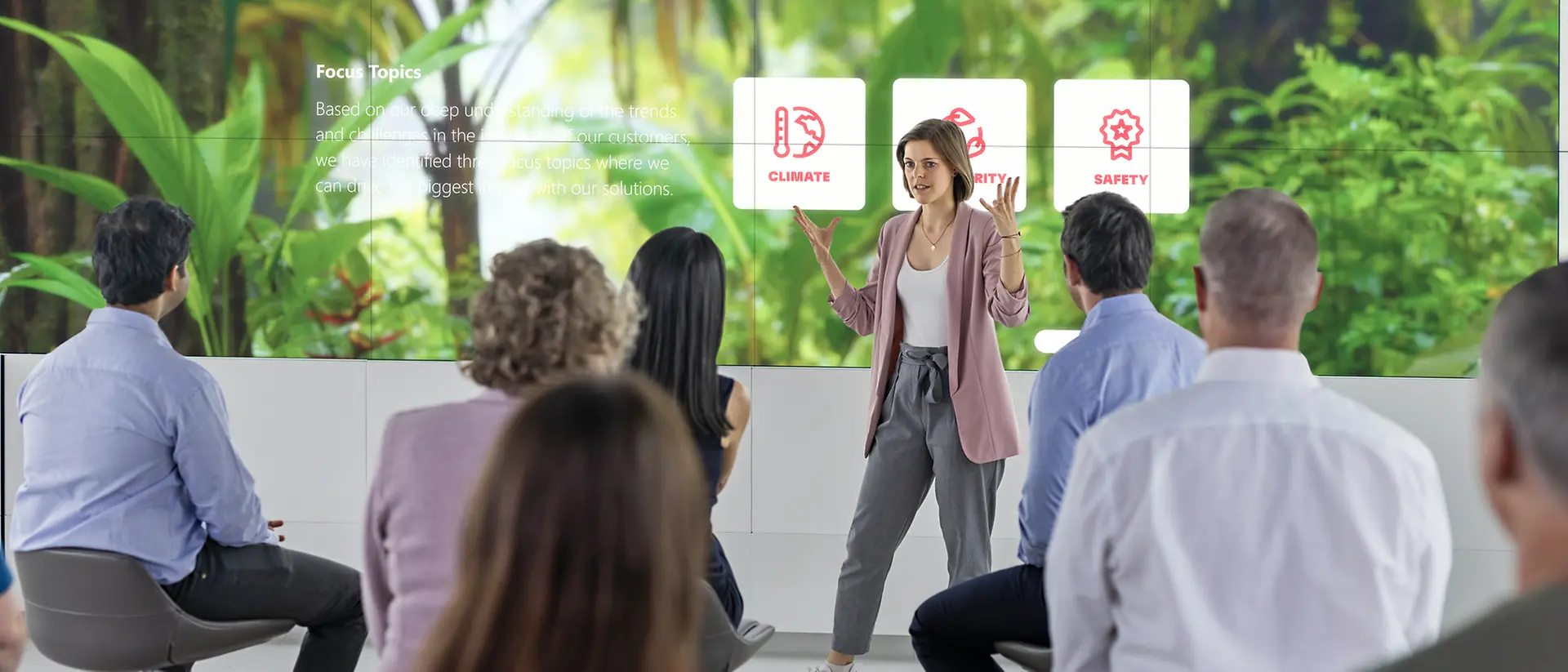 A customer experience tour guide presents the Adhesive Technologies portfolio focusing on sustainable solutions to a group of customers in the 270° Infinity Room.