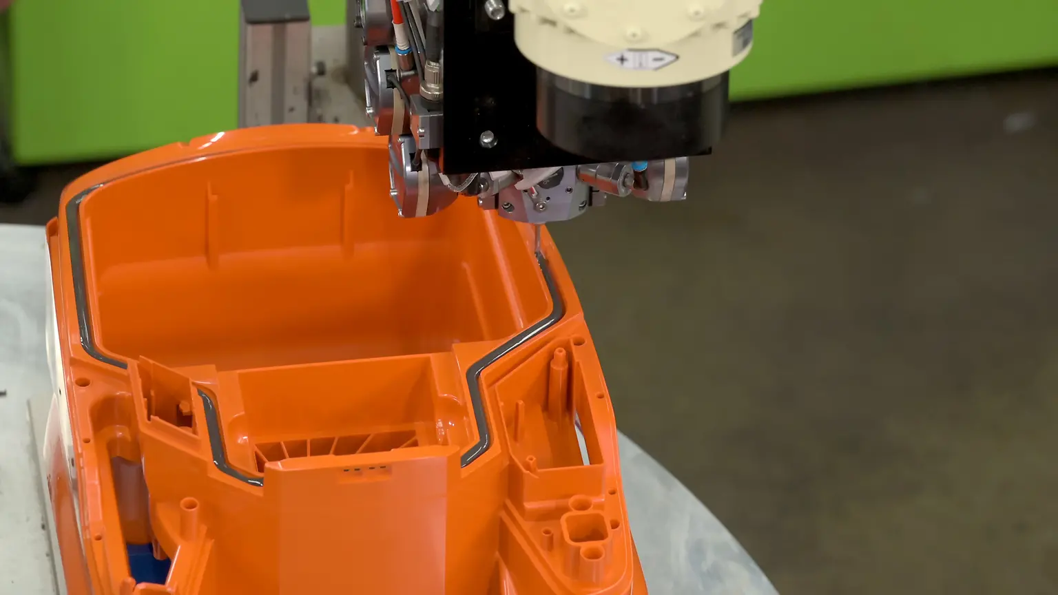 
The mixing head mounted on the 6-axis robot applies 2K polyurethane foam into the groove to seal the vacuum cleaner housing.