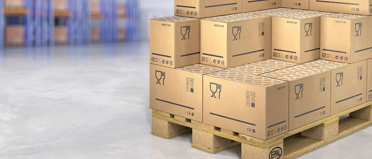 Large paper cartons on a pallet in a warehouse.