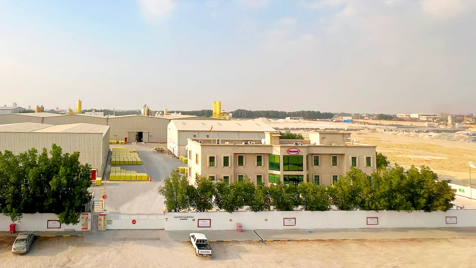 Office building with Henkel logo on it and several plants.