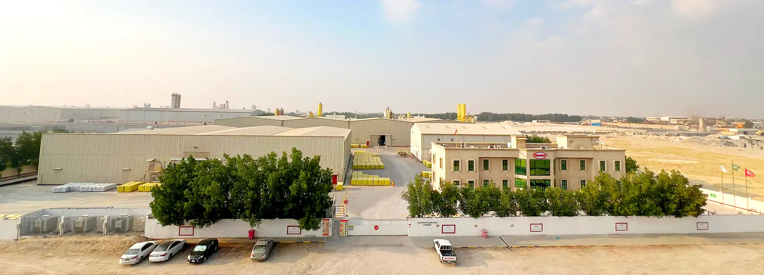 Office building with Henkel logo on it and several plants.