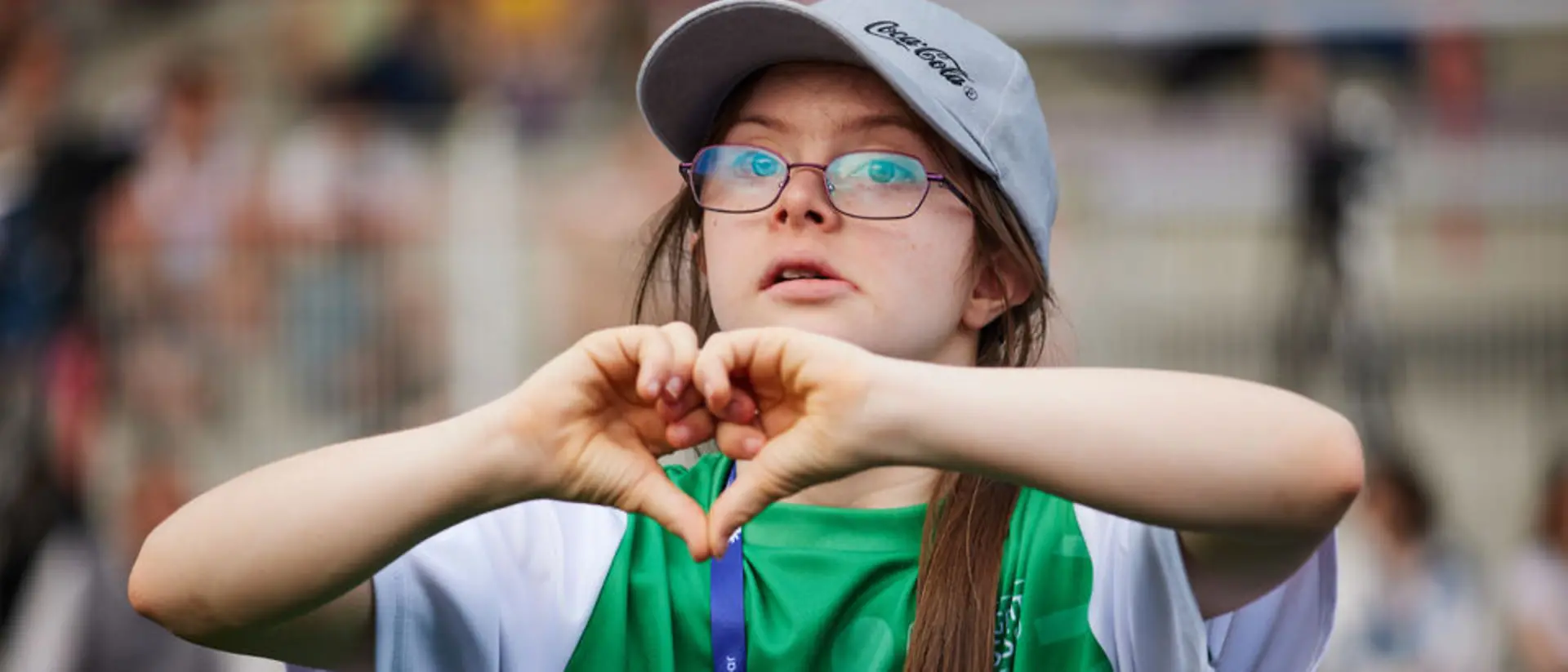 A girl forms a heart with her hands.