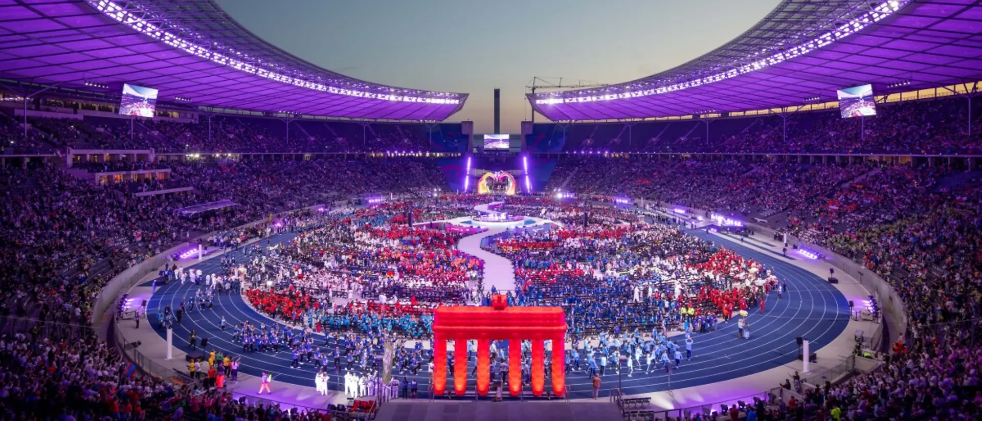 The large stadium in Berlin, where the Special Olympics 2023 took place, is full of people and lit up with colorful lights.