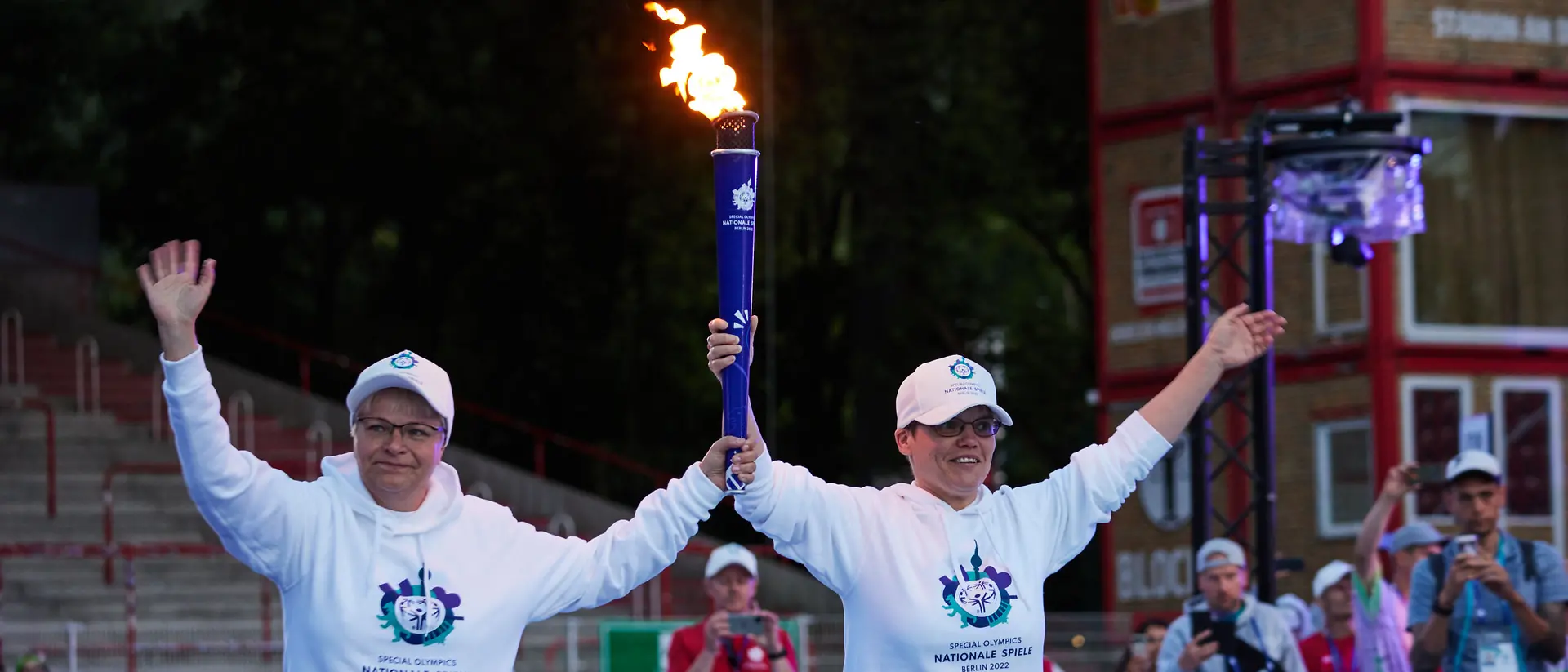 Two volunteers carry the Special Olympics Flame.