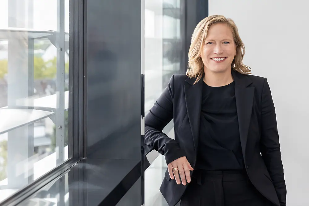 Woman leaning in front of a window 