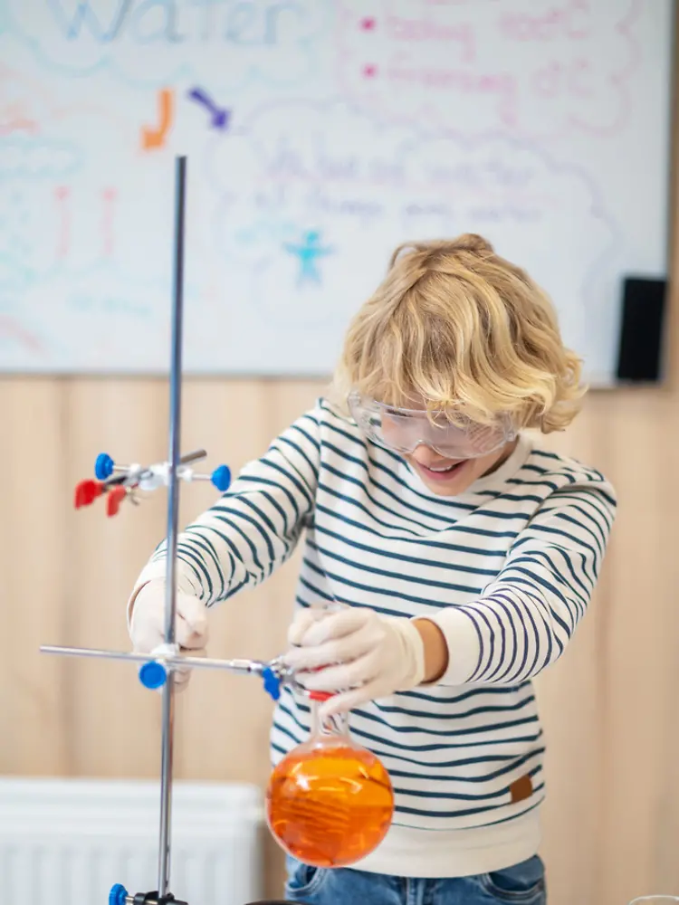 boy-placing-test-tube-tripod