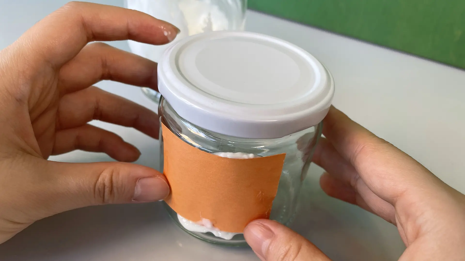 将一张涂有乳酪胶的纸贴在果酱罐上
