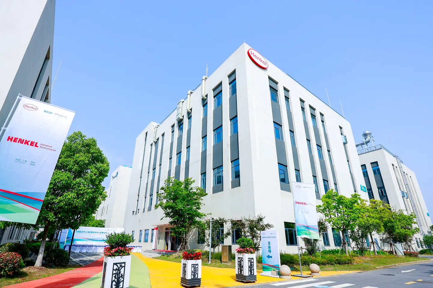 Wide-angle shot of a white building with a Henkel Logo.