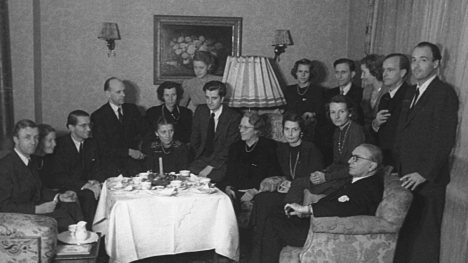 Black and white photo of members of the Henkel Family in 1947. They are gathered around a living room table.