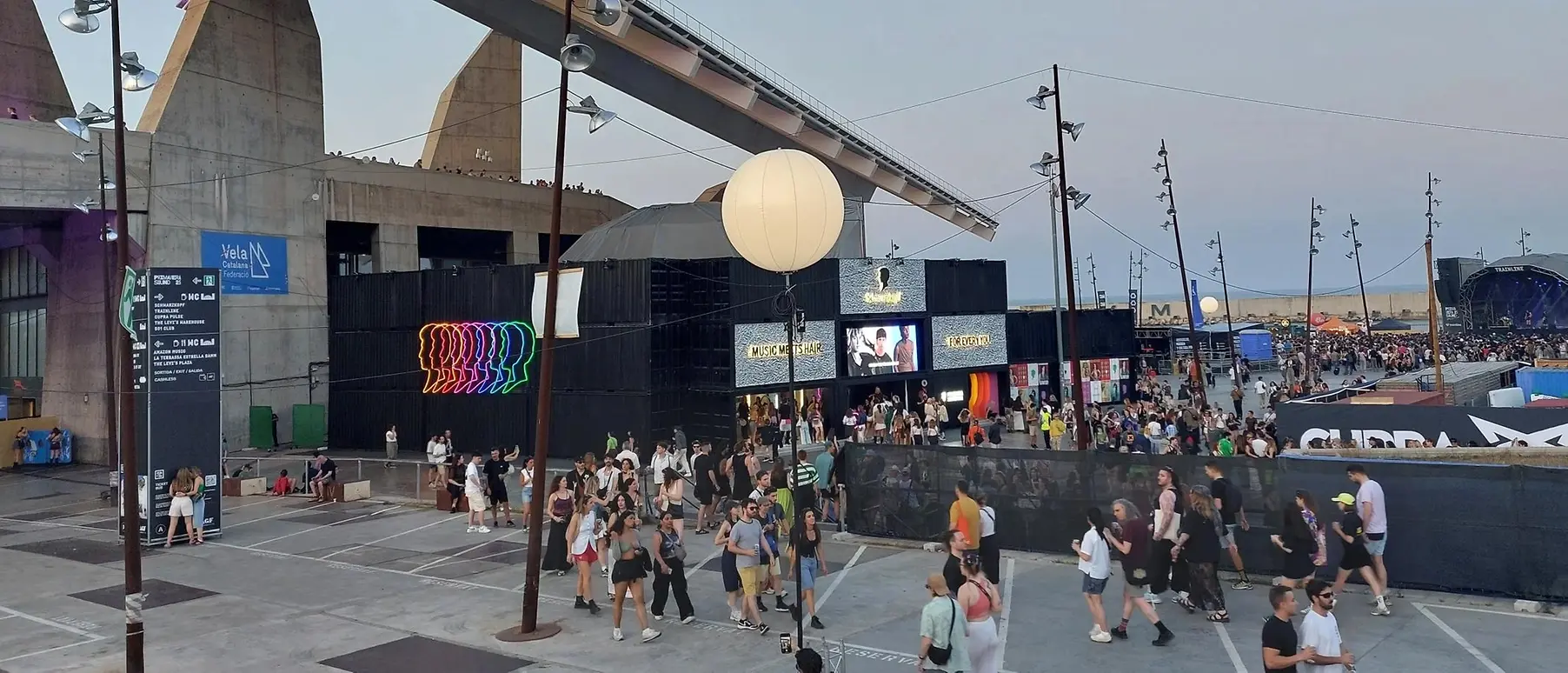 Stage with Schwarzkopf logo at a music festival, with crowds of people.