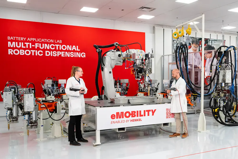 Two scientists working together in a battery application laboratory with specialized equipment.