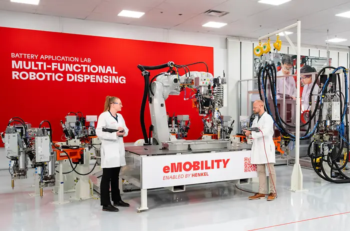 Two scientists working together in a battery application laboratory with specialized equipment.