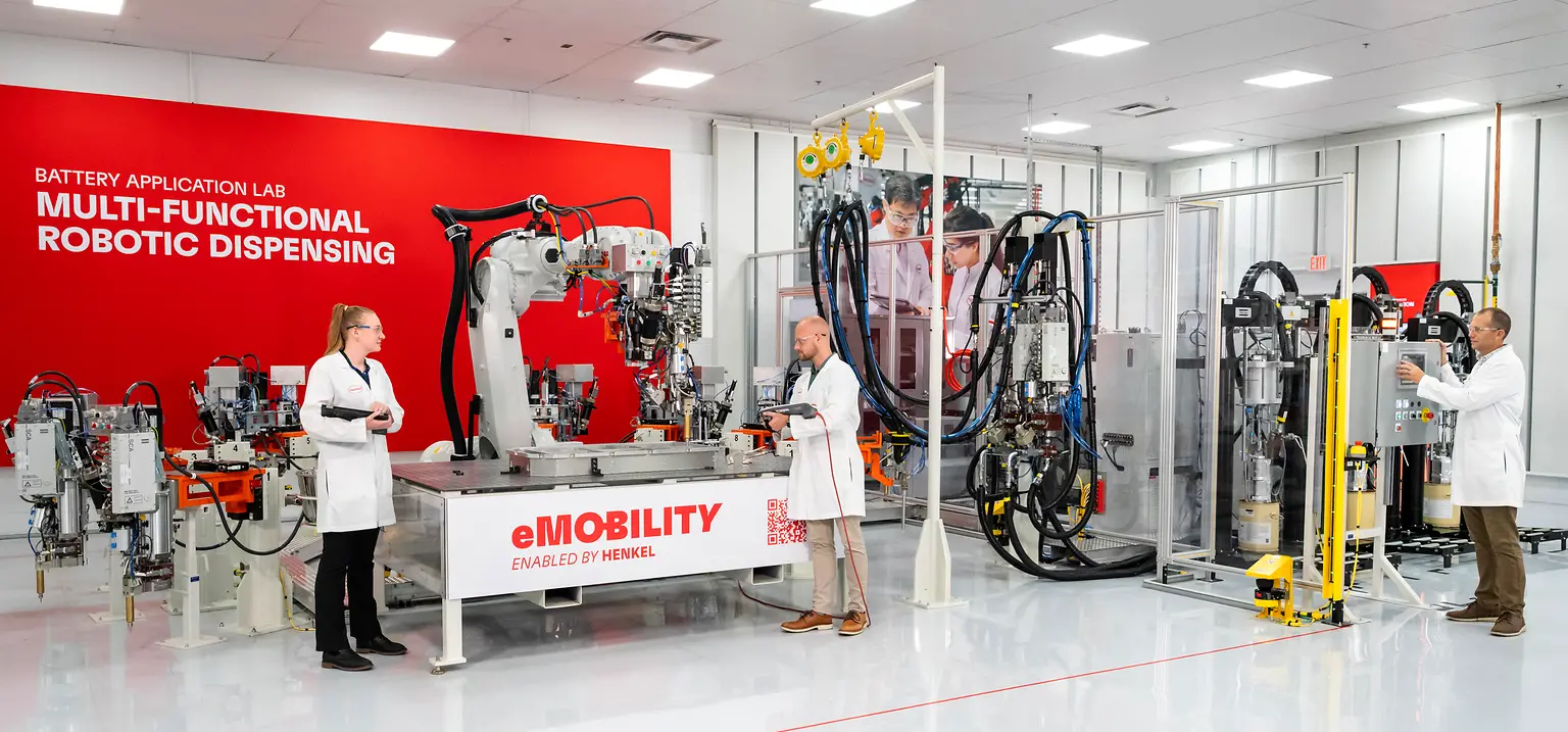 Two scientists working together in a battery application laboratory with specialized equipment.