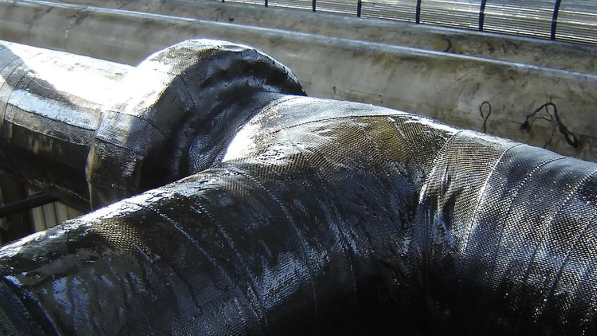 Industrial pipes covered with black insulation.