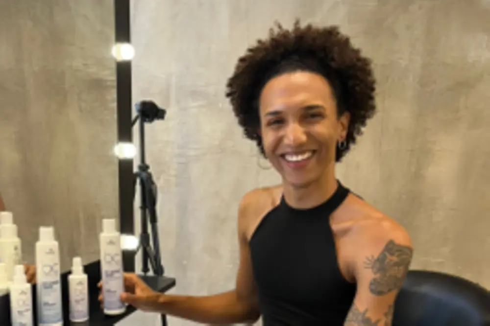 Guina is sitting in salon chaire and smiles into the camera.
