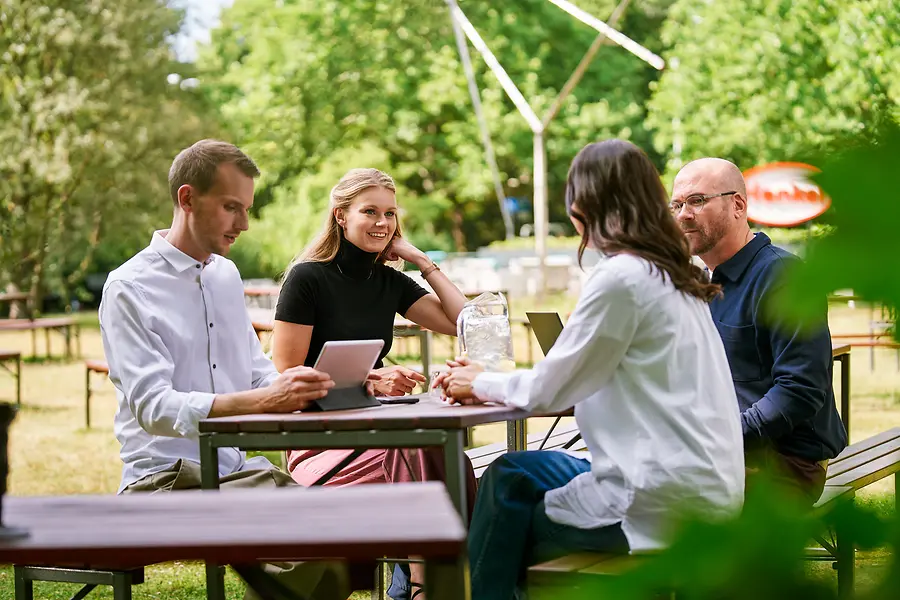 Collage of two images and a text field: the first picture shows four collegues sitting outside, the second shows a liquid with pearls.