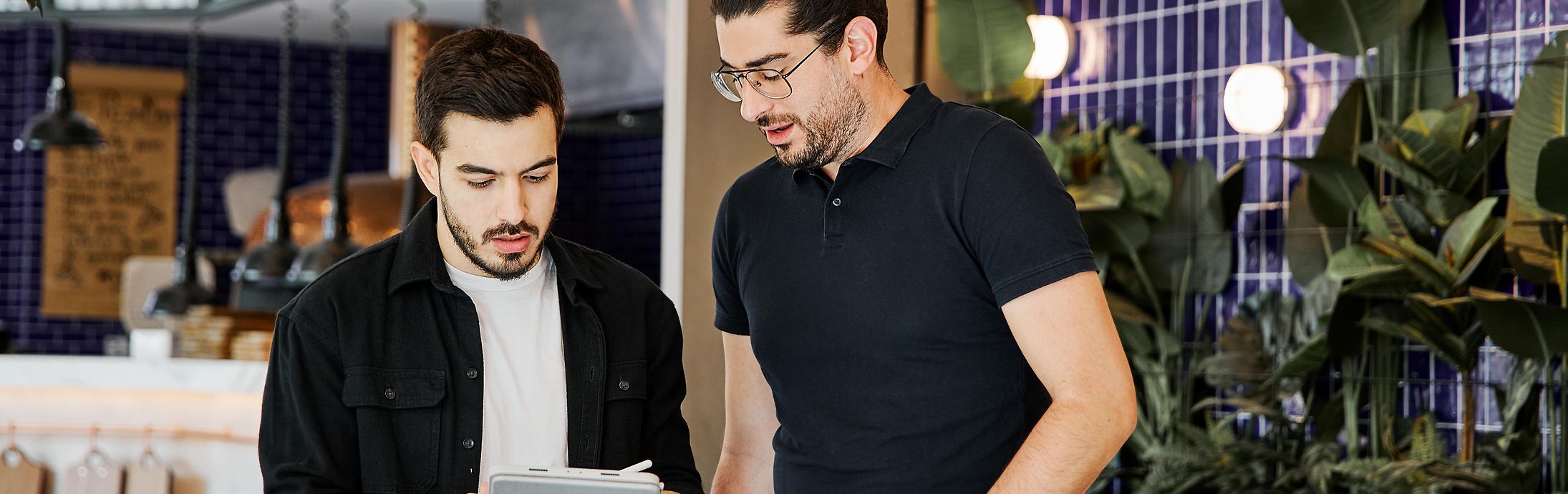 Collage of one image and a text field: the first picture shows two colleagues working together in a relaxed, casual office setting. The second picture shows a structure. 