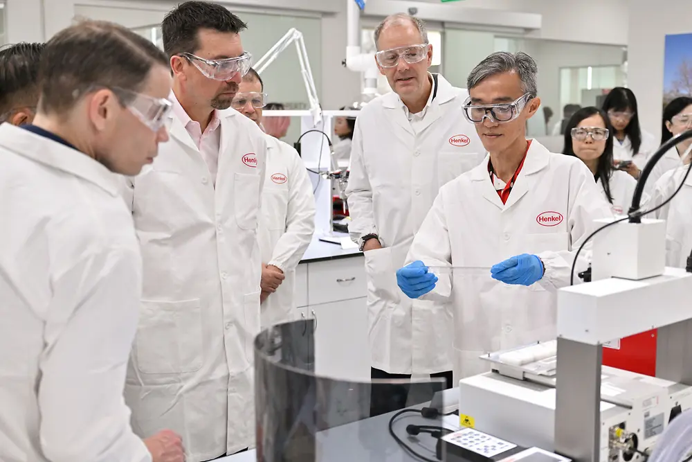 People watching a man doing a lab demonstration. 