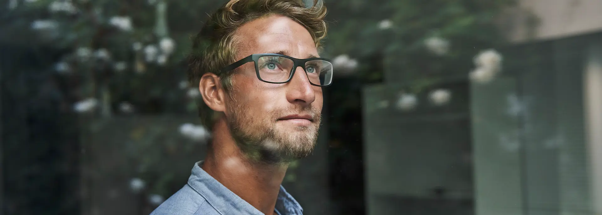 Man staring out the window, lost in thought.