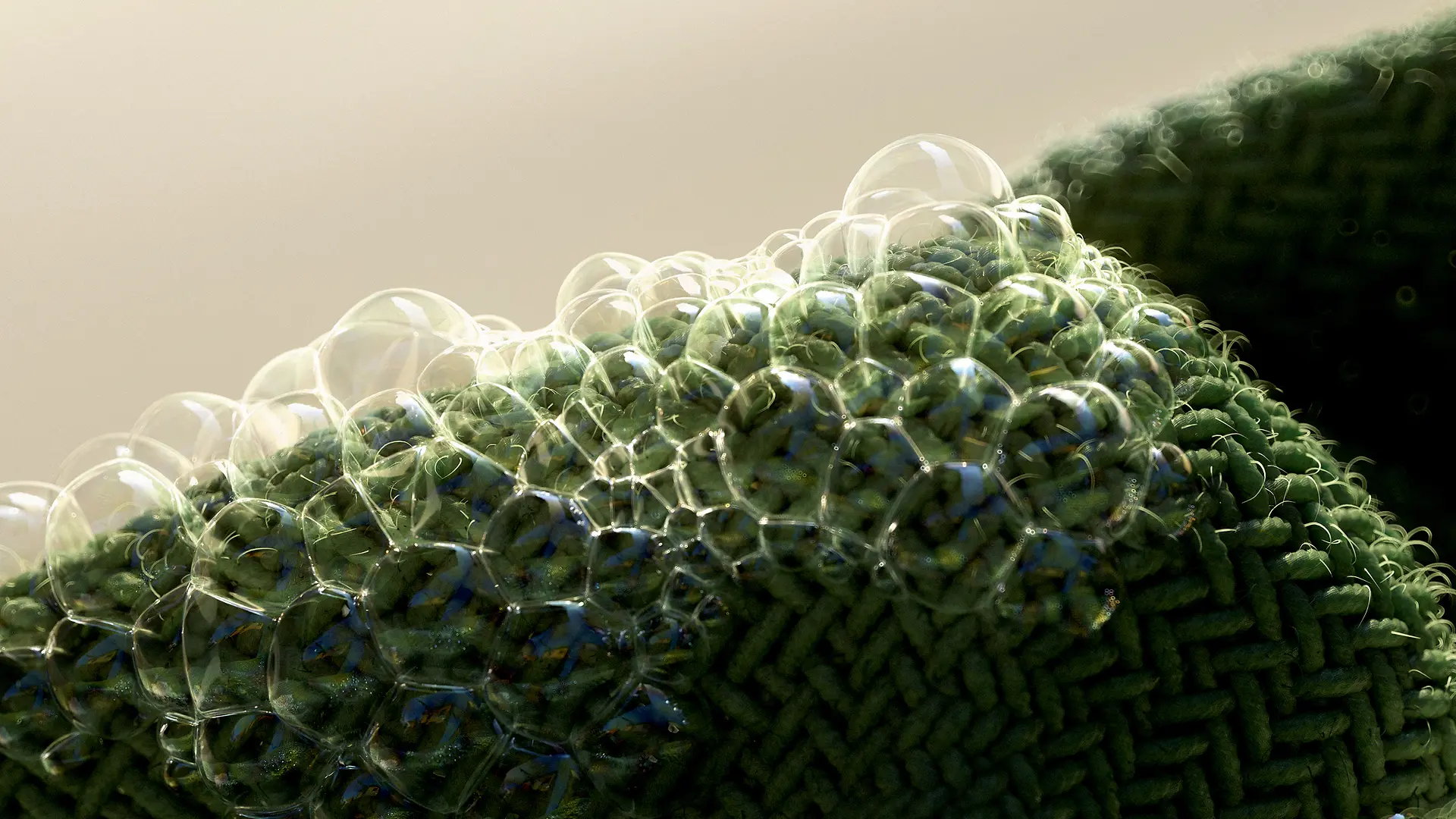 A close‑up of a green fabric surface covered with small soap bubbles along the edge.