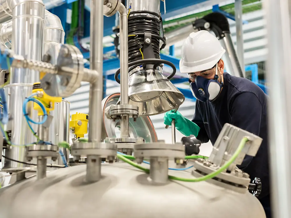 
Operator working on mixer reactor during material processing