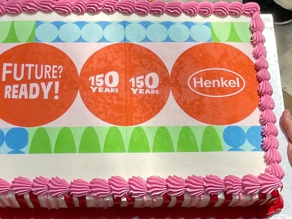 A decorated anniversary cake features the slogans “Future? Ready!” and “150 Years” alongside the Henkel logo.