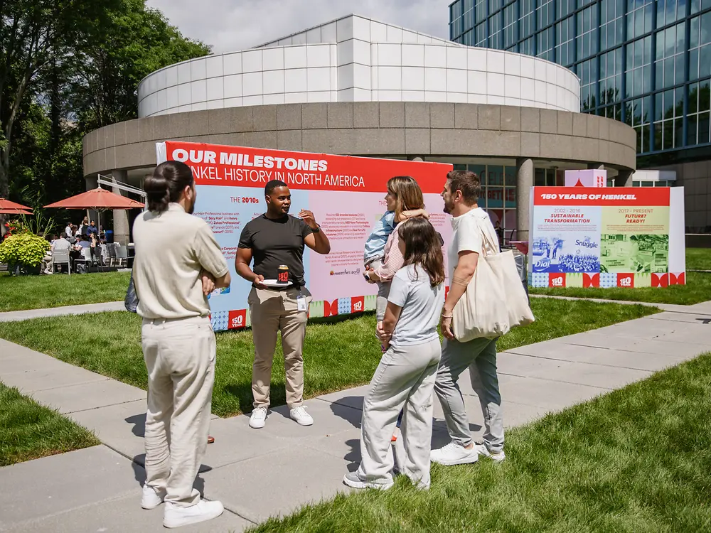 Employees view an outdoor exhibition highlighting milestones from Henkel’s history in North America.