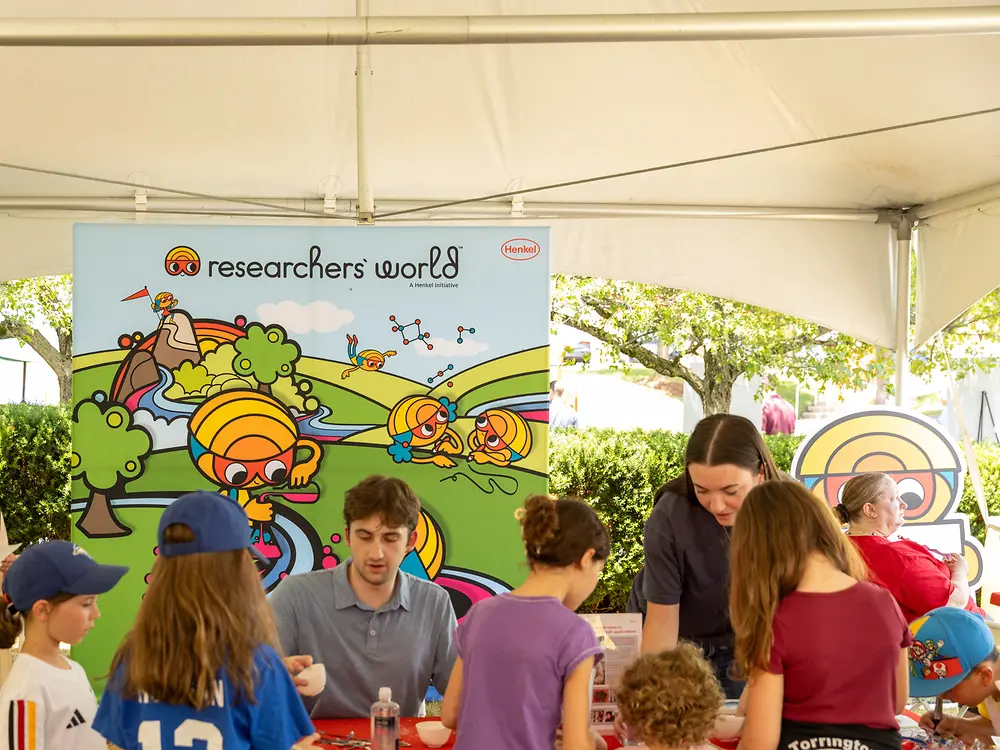 Children participating in a hands-on science activity at a workshop table.