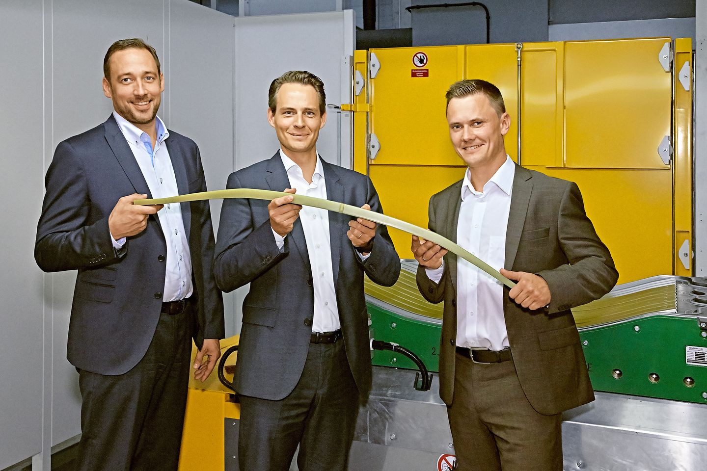 Frank Fetscher, Frank Kerstan and Oleg Schelesnikow with a composite leaf spring produced for Volvo Cars.