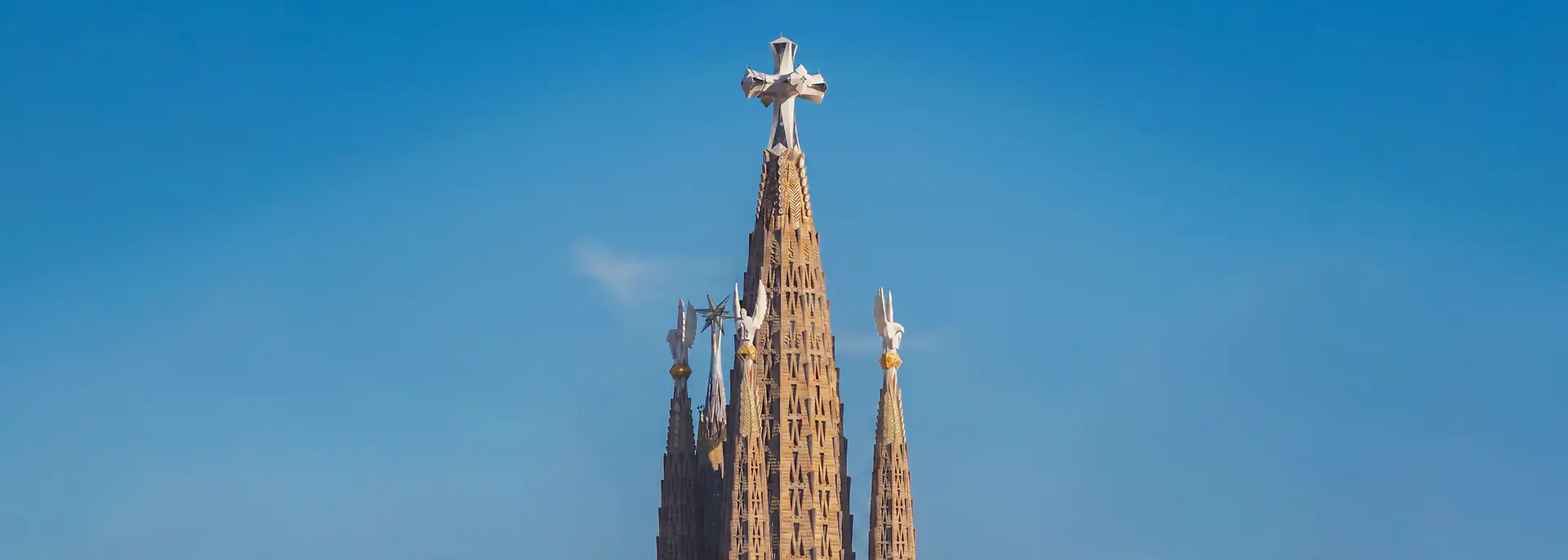 The tallest towers of the Sagrada Familia against a blue sky