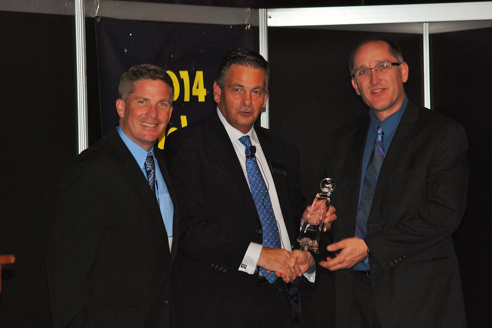 Henkel’s Michael Pierce (far left) and Dr. Dwight Heinrich (far right) are presented with the Global Technology Award from Trevor Galbraith (center), Publisher of Global SMT and Packaging magazine.
