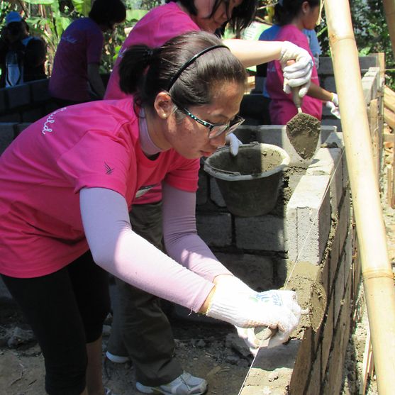 female-volunteer-laying-bricks