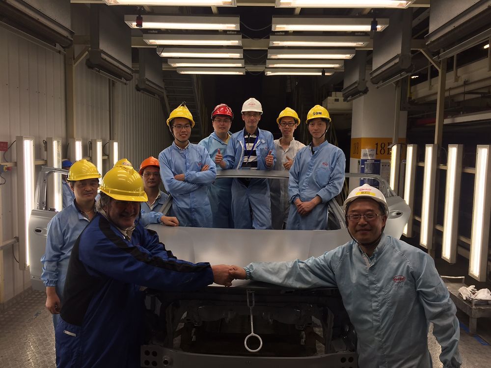 Henkel team with first treated car body after the brownfield conversion. 